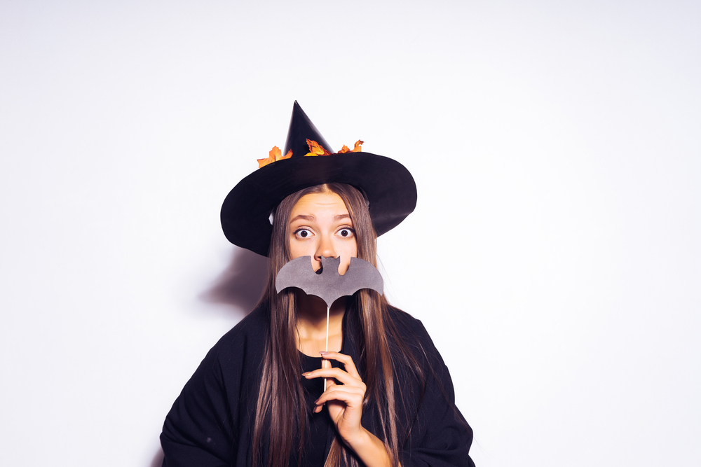 Chica joven posando en un disfraz de bruja para halloween