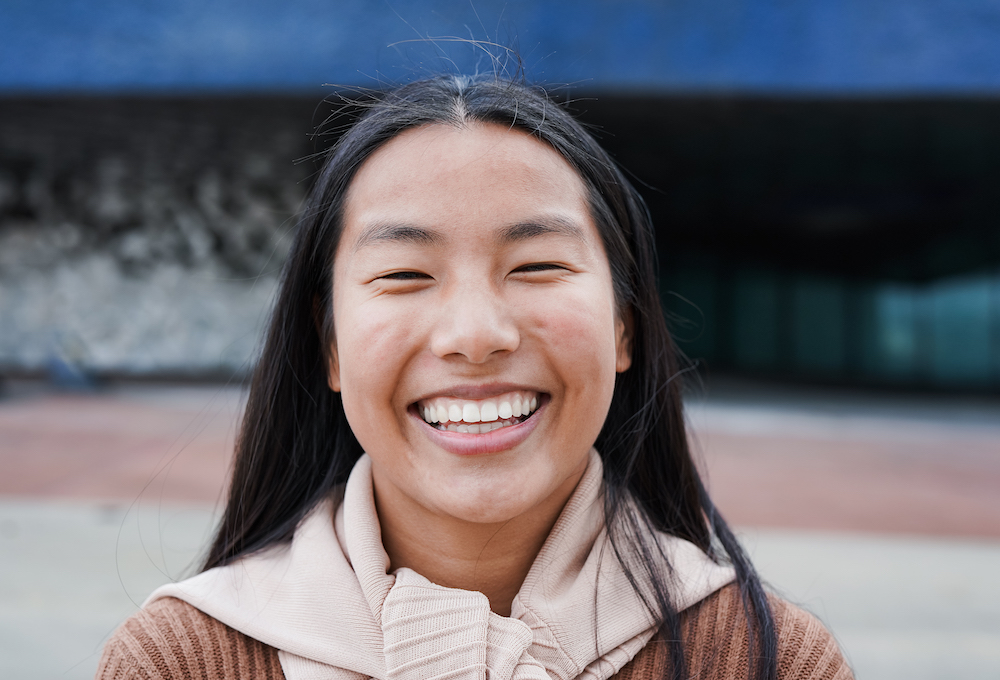 Feliz joven asiática sonriendo a la cámara